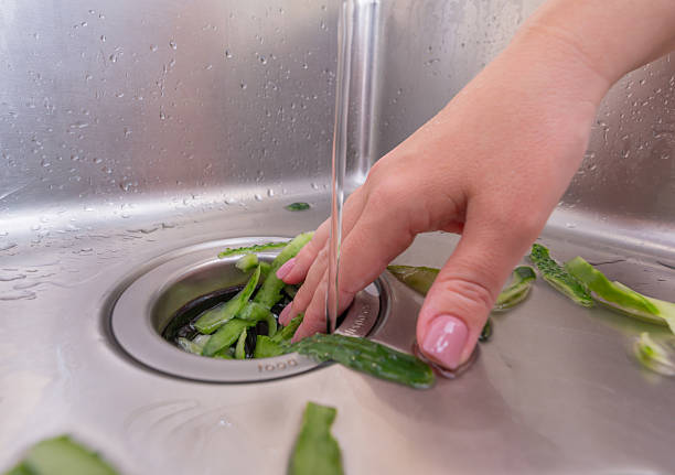 istock Recycling food scraps: fresh vegetable peels entering a garbage disposal system 2211860563