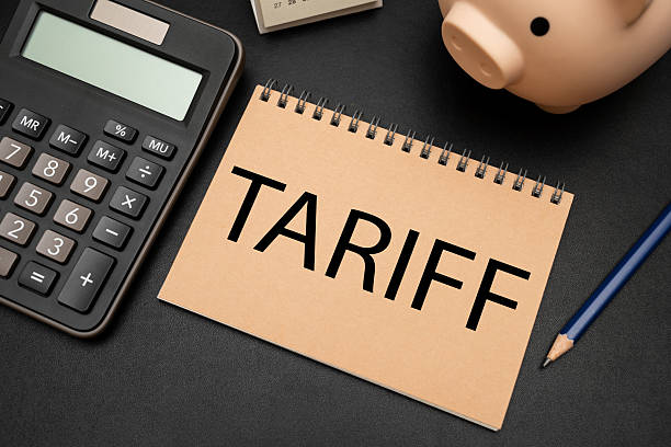 istock TARIFF text on Notebook with calculator and office supplies. 2211864443
