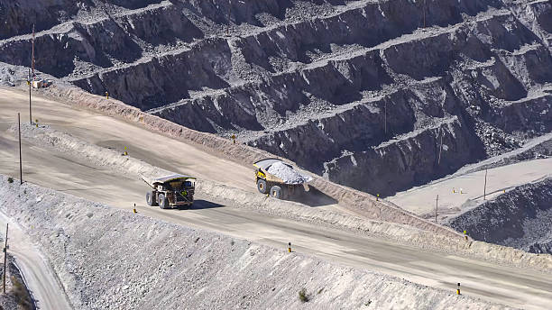 istock Giant mining trucks transporting minerals in an open pit mine 2211866611
