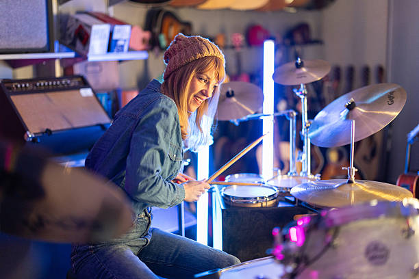 istock Passionate female drummer practicing her skills in neon lit studio 2211869666