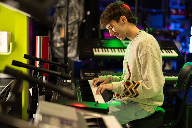 istock Young man playing synthesizer in music shop 2211870454
