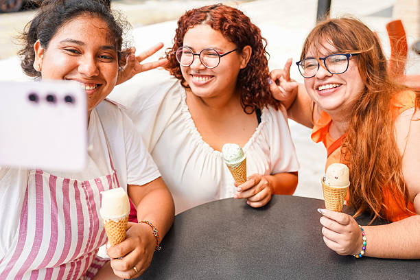 istock Three latin women taking a selfie while eating ice cream cones 2211874530