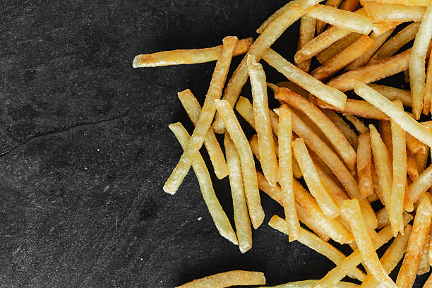 istock Crispy Golden French Fries on Dark Surface for Culinary Background 2211874949