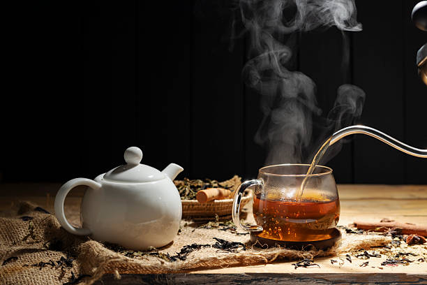 istock Pour hot tea into cups, herbal tea glasses are arranged on a rustic wooden table. 2211875139
