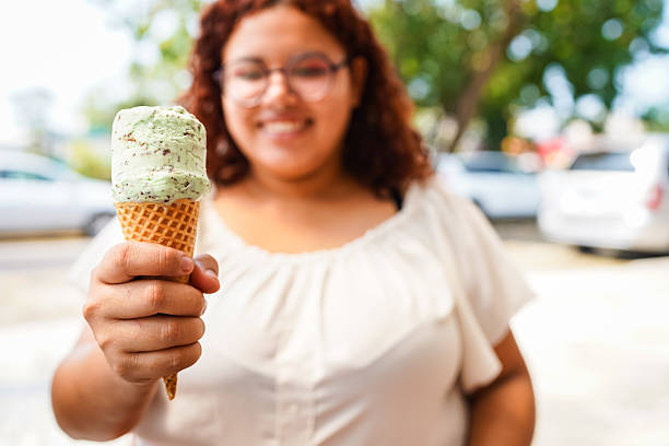 Latin woman showing a delicious pistachio ice cream cone