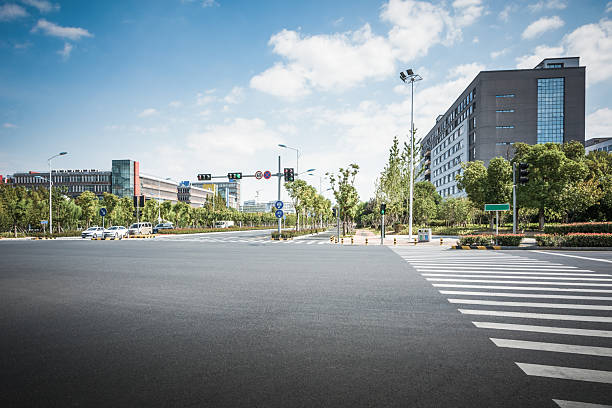 istock Serene Urban Intersection with Lush Greenery and Modern Architecture Under Bright Blue Sky 2211875305