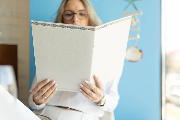istock Woman Holding Restaurant Menu, Menu in Focus 2211875786