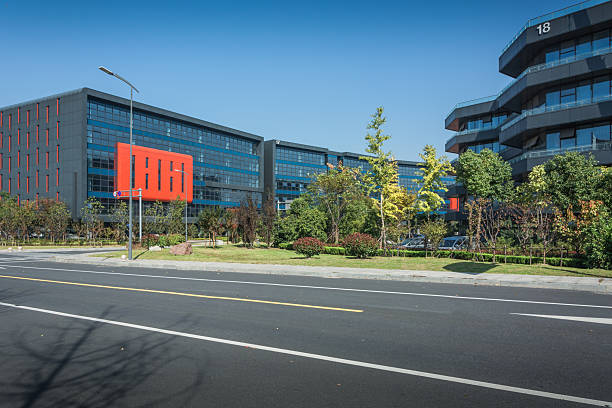 istock Urban Modern Office Complex Surrounded by Lush Greenery and Clear Blue Sky 2211878290