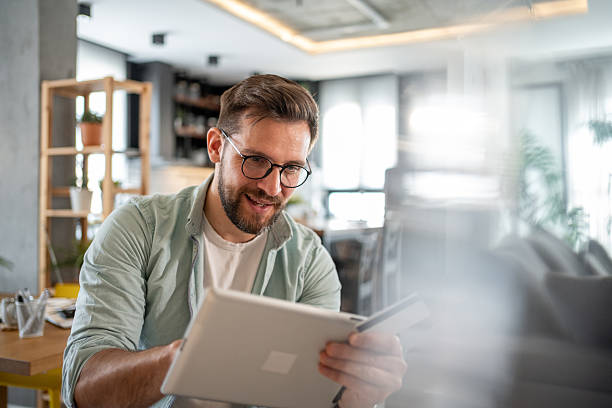 istock Young man shopping online using digital tablet and credit card at home 2211879340