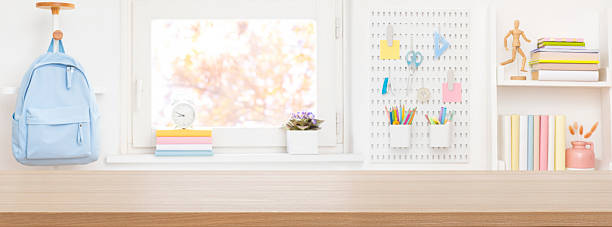 istock Wide wooden table top for presentation on blurred educational room interior background 2211882625