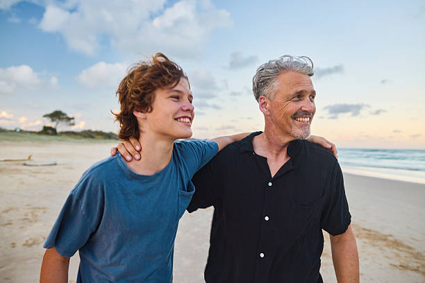 istock Father and son walking on the beach at sunset in australia 2211885013