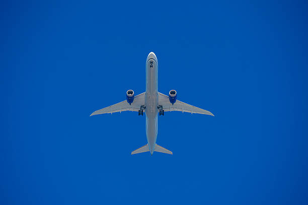 istock Airplane flying overhead against a clear blue sky 2211886444
