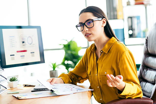 istock Skilled professional businesswoman working with documents in a modern brightly lit office workspace showcasing work engagement. 2211889972