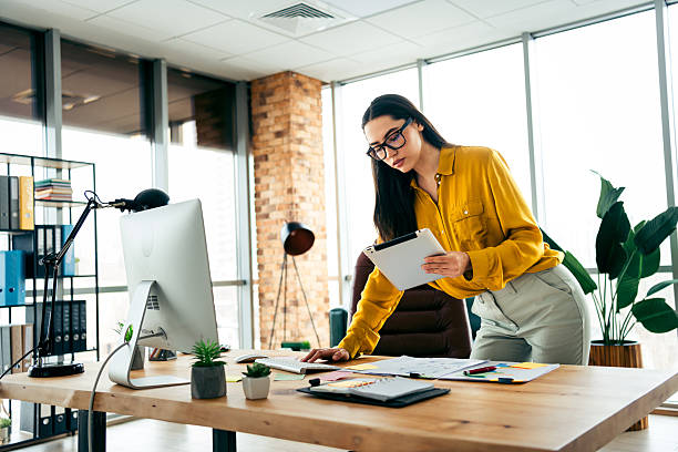 istock Business professional working in a modern office environment with natural daylight, showcasing confidence as she focuses on tasks 2211890008