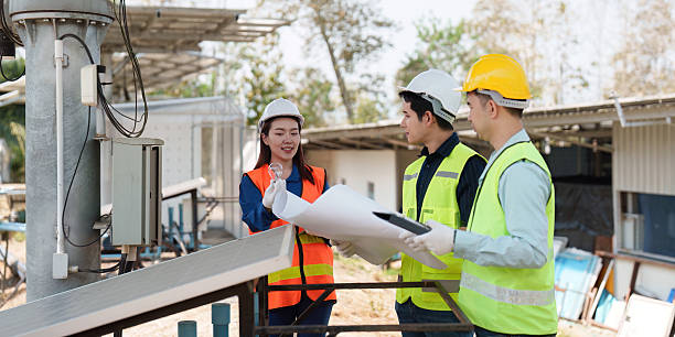 istock Sustainable Infrastructure and Teamwork. Engineers reviewing plans and discussing the installation of solar panels in an eco-friendly setting. 2211892092