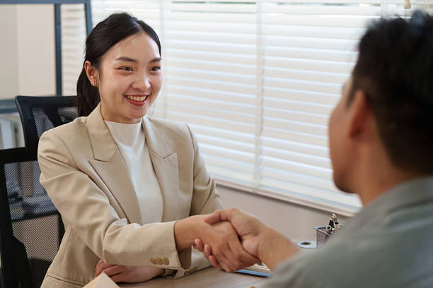istock Real Estate and Client Engagement. A real estate agent discusses terms with a client during a meeting. 2211892175