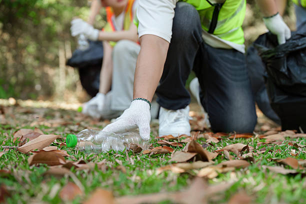 istock Teamwork and Eco-consciousness. Volunteers gather trash in a park, demonstrating teamwork and community spirit during a sustainability-focused cleanup. 2211892483