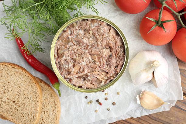 istock Canned meat in tin can served on wooden table, flat lay 2211893475