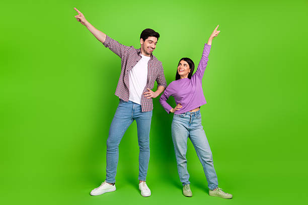 istock Joyful couple posing with enthusiastic gestures on a vibrant green backdrop symbolizing happiness, bonding, and youthful energy 2211894283