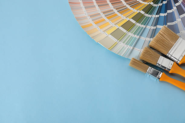 istock Color selection charts and paint brushes on light blue table, space for text. Decorating and design 2211895312