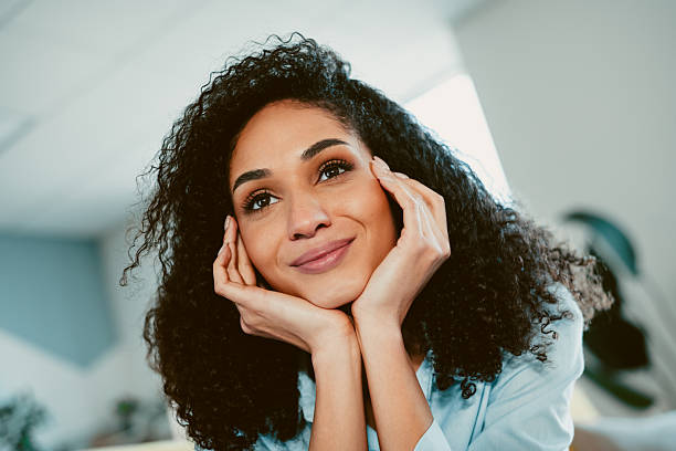 istock Charming young woman relaxing indoors with a thoughtful and cheerful expression on her face, enjoying a peaceful and serene moment 2211895385