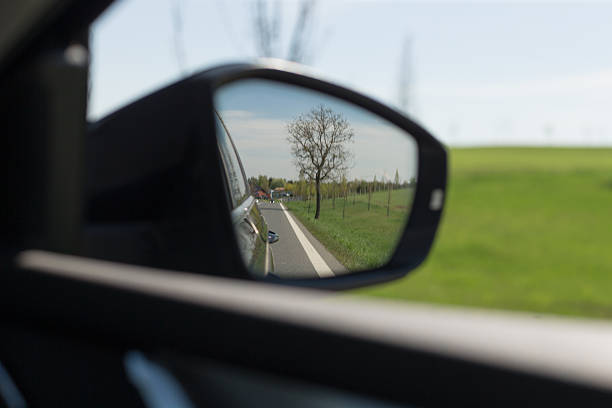 istock A rearview mirror reflection shows the open road and stunning nature 2211895913