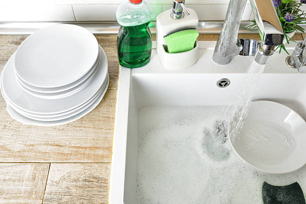 istock Kitchen sink with dishes and a faucet dripping water 2211896108