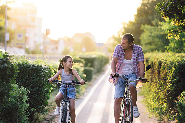 istock Father and daughter enjoying bicycle ride together 2211896296