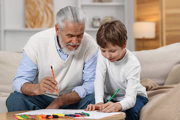 istock Grandpa and his grandson drawing at table indoors 2211896842