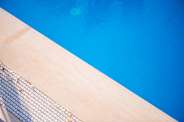 A close-up, macro shot capturing the fine details of a swimming pool scene—sparkling water, textured surfaces, and reflections of light—bringing summer vibes to life.