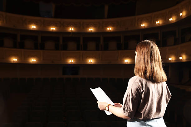 istock Professional actress rehearsing on stage in theatre, back view 2211899131