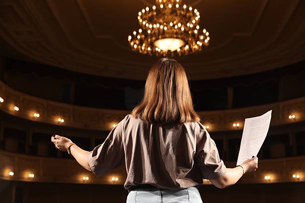 istock Professional actress rehearsing on stage in theatre, back view 2211899799