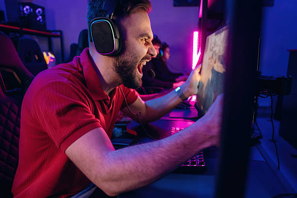 istock Man is mad, screaming, angry. Gamers are playing video game by computers 2211900223