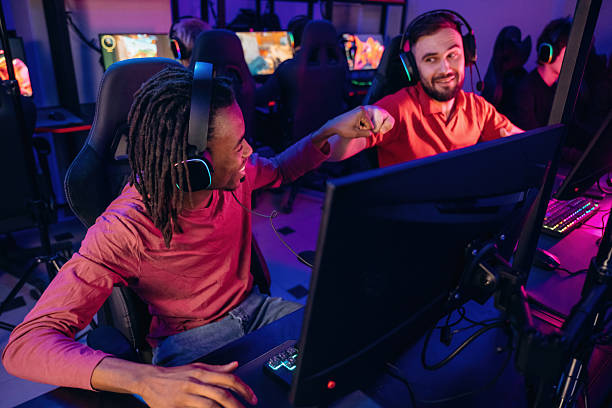istock Victory, nice job, hands gestures. Gamers are playing video game by computers 2211900267