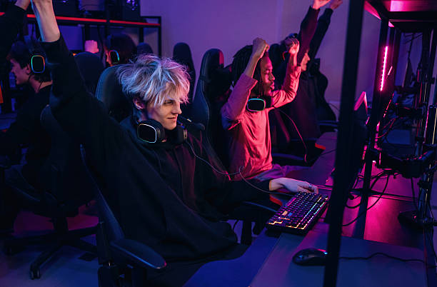 istock Celebrating victory. Gamers are playing video game by computers 2211900503