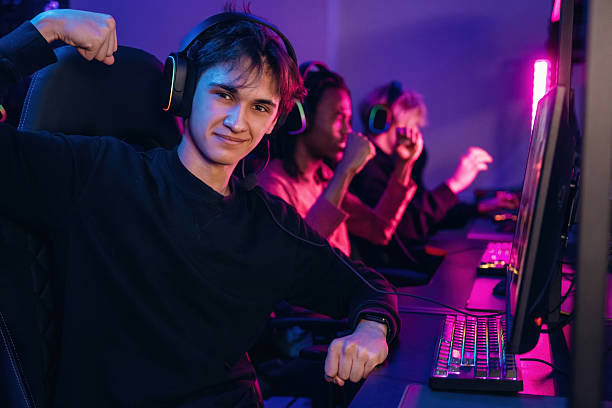 istock Team has won. Gamers are playing video game by computers 2211900652