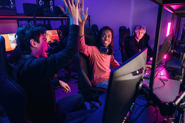 istock Celebrating victory. Gamers are playing video game by computers 2211900673