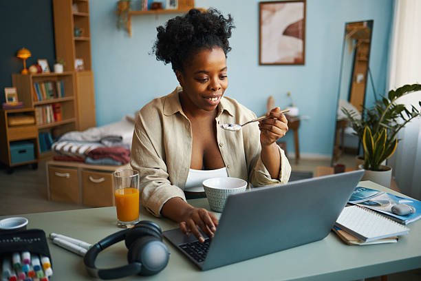istock Portrait of Focused Woman Eating Breakfast While Working Remotely 2211904319