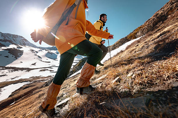 Two hikers goes uphill high in mountains