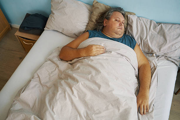 istock Sleeping Man Resting Comfortably in a Bed 2211904501