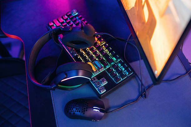 istock Table with keyboard. Gaming computer is in the dark room with neon lighting 2211906272