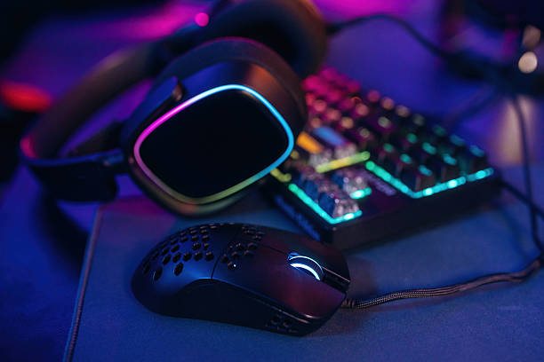 istock Table with keyboard. Gaming computer is in the dark room with neon lighting 2211906275