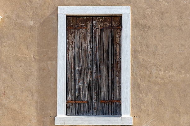 istock Rustic Wooden Shutter on Mediterranean Stucco Wall 2211907990
