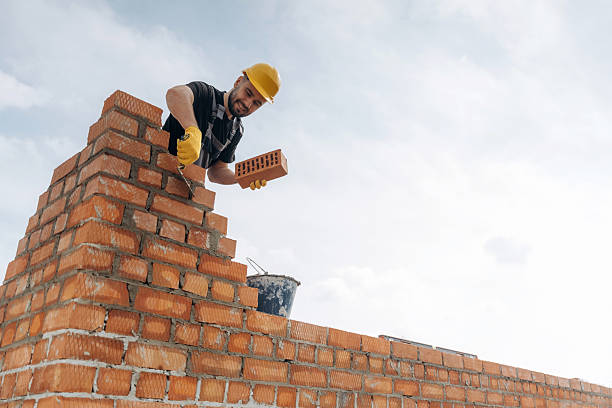 istock High up, placing bricks. Construction worker is at job outdoors 2211910310