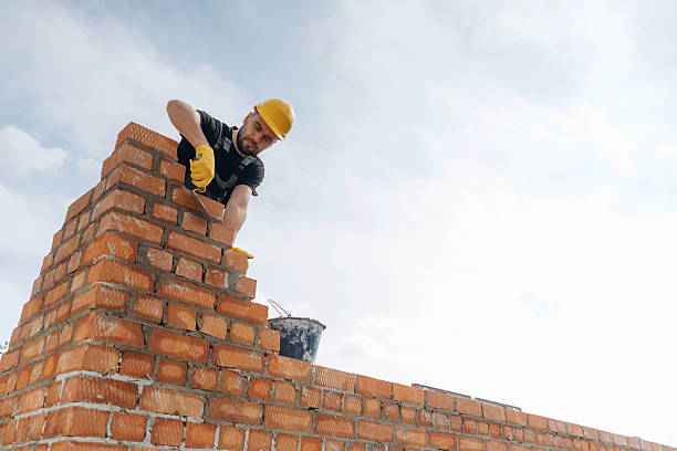 istock High up, placing bricks. Construction worker is at job outdoors 2211910311
