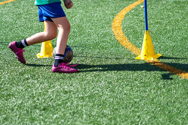 istock Young soccer player dribbling ball on artificial turf 2211910328