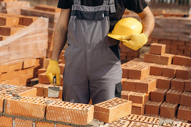 istock Holding hard hat. Close up view of construction man that is working with bricks 2211910420