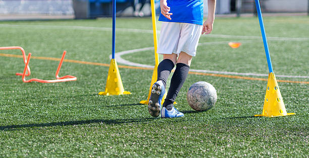 istock Young soccer player dribbling ball during training on turf field 2211911078