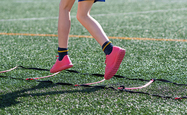 istock Young athlete performing agility exercises with speed ladder on turf field 2211911137