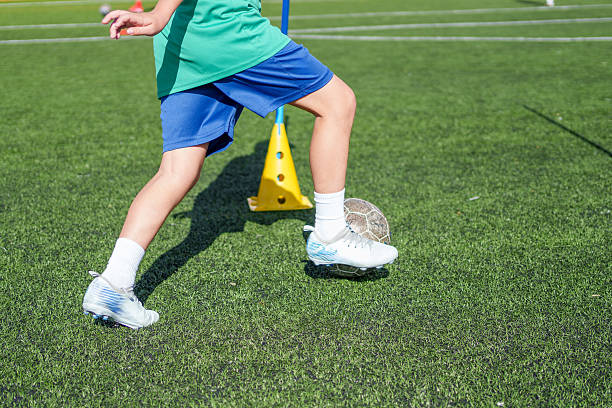 istock Young soccer player dribbling ball during training on turf field 2211911252
